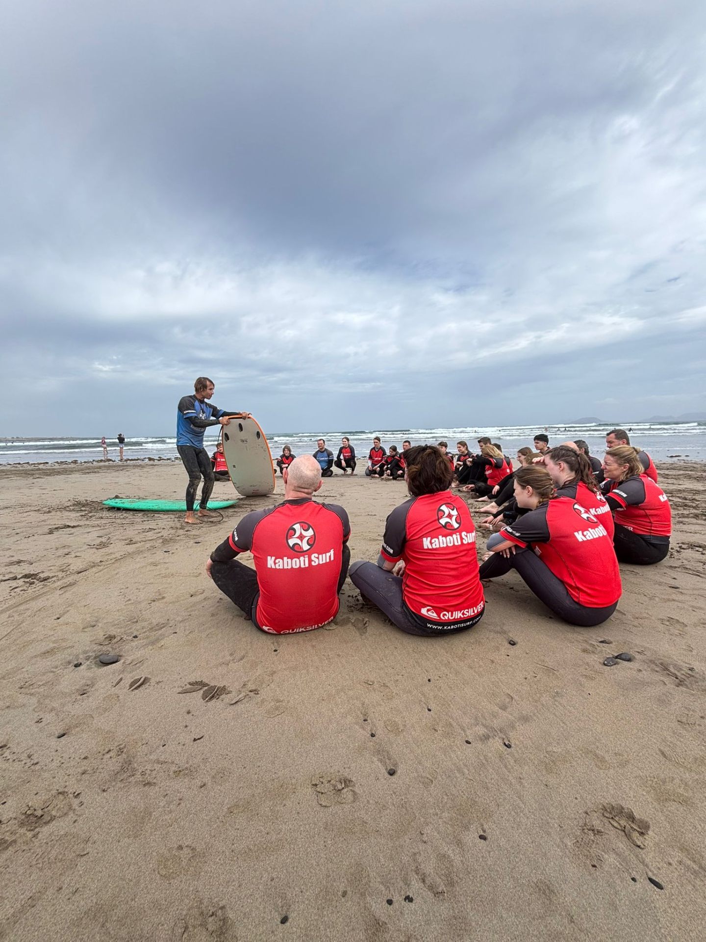 Kaboti Surf instructor giving a theory session on the sand at Famara